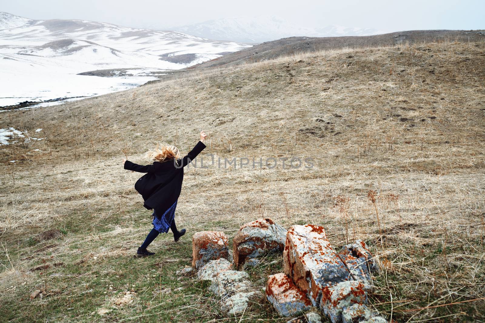 Woman running away in the snow landscape