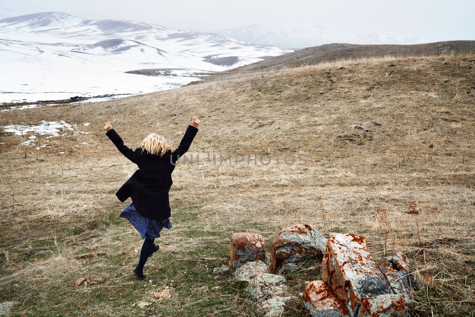 Woman running away in the snow landscape