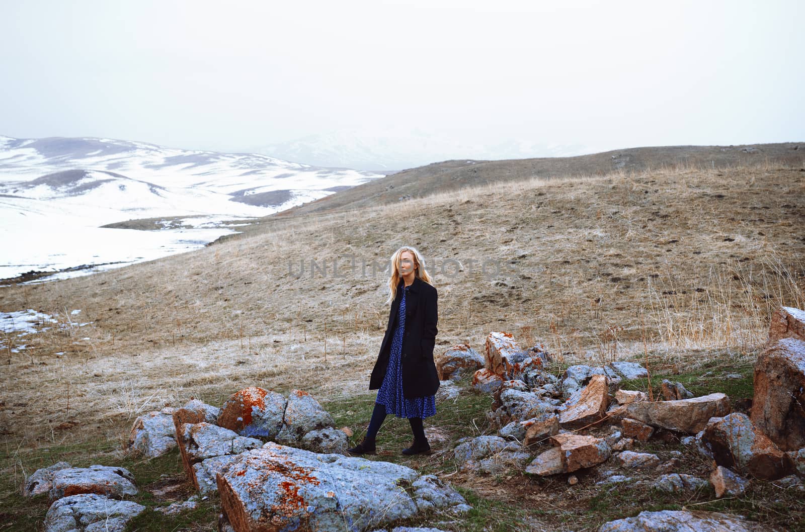 Serious woman walking in the winter landscape by Novic