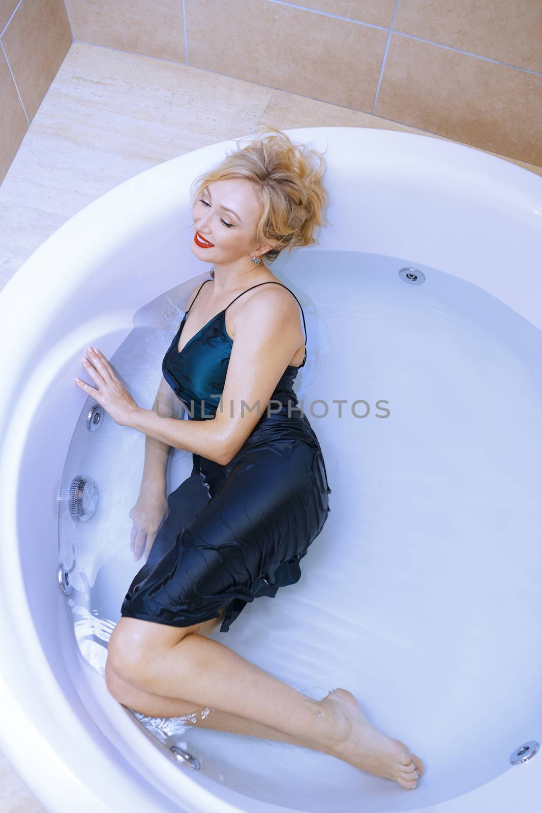 Woman wearing slip dress relaxing in the bath