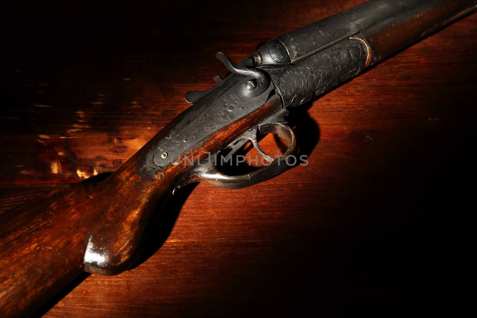 Ancient hunting shotgun closeup on wooden background
