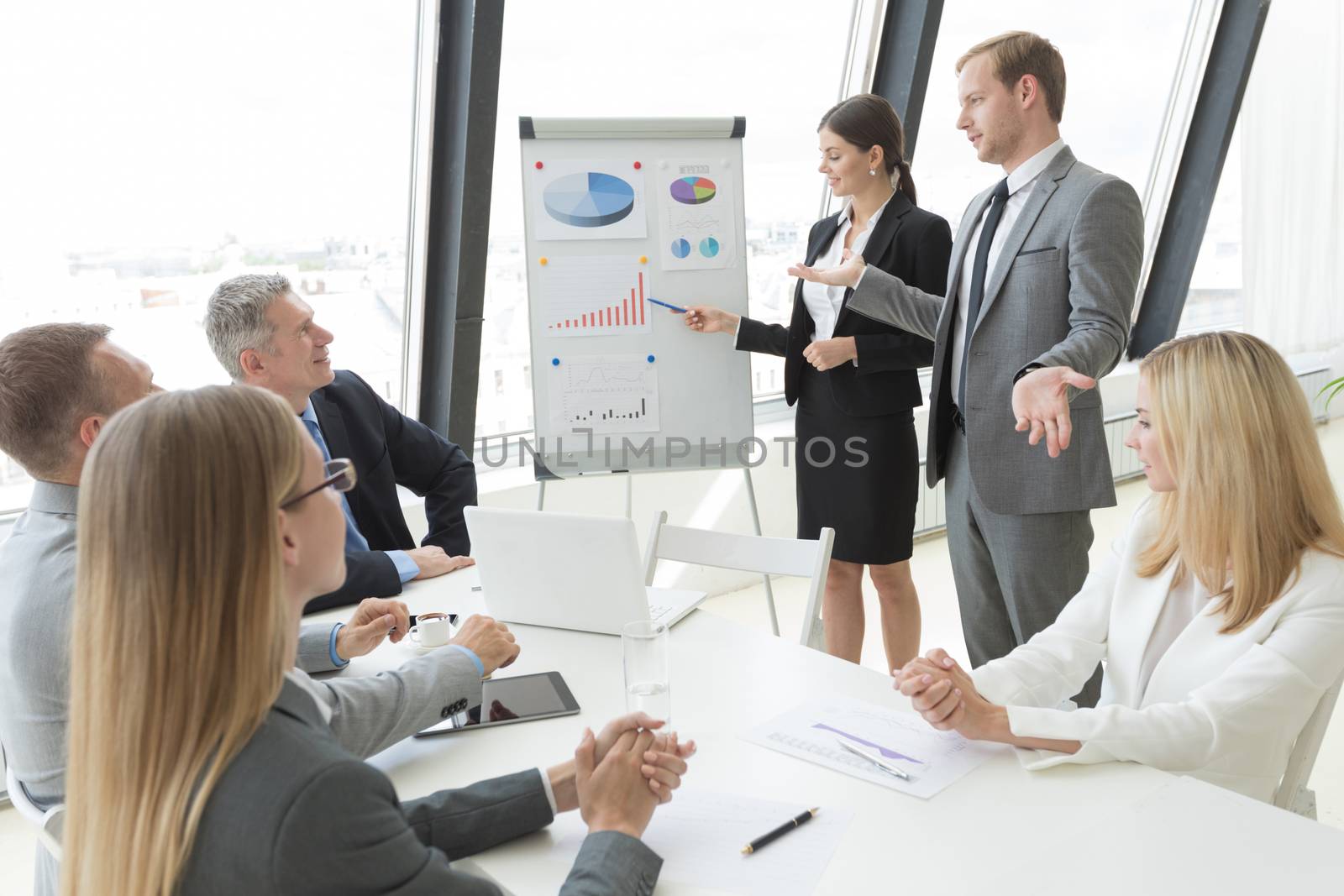 Businesswoman pointing at a chart on a whiteboard during business meeting