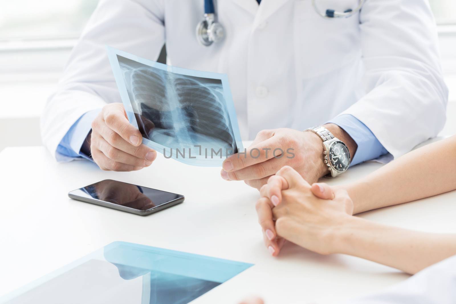 medical colleagues discuss x-ray sitting at the office table