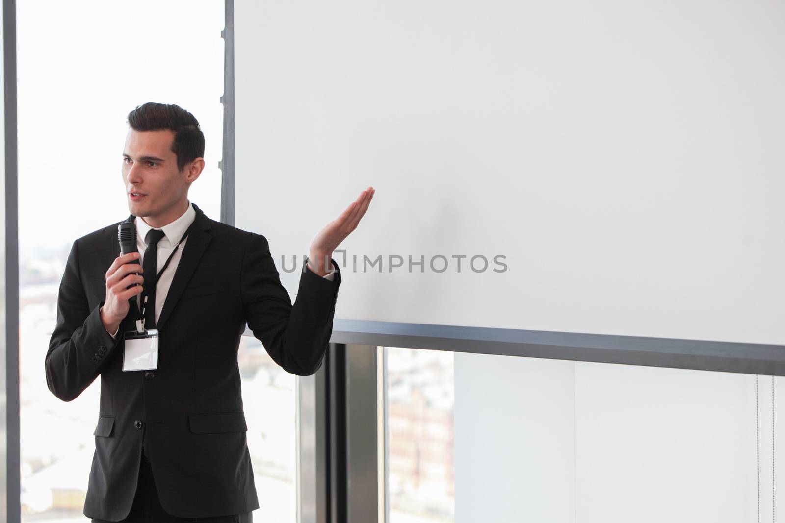 Businessman giving a presentation on blank white board with copy space