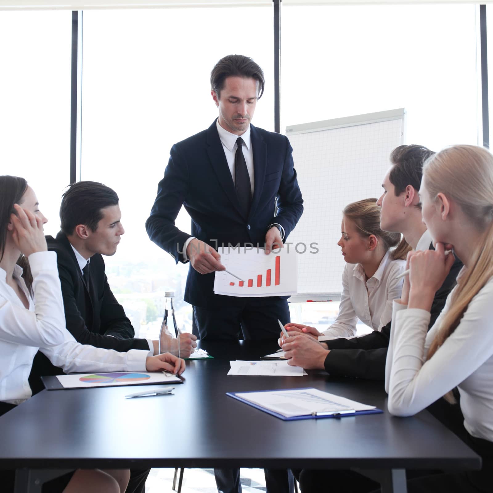 Business man showing financial statistics graph at meeting