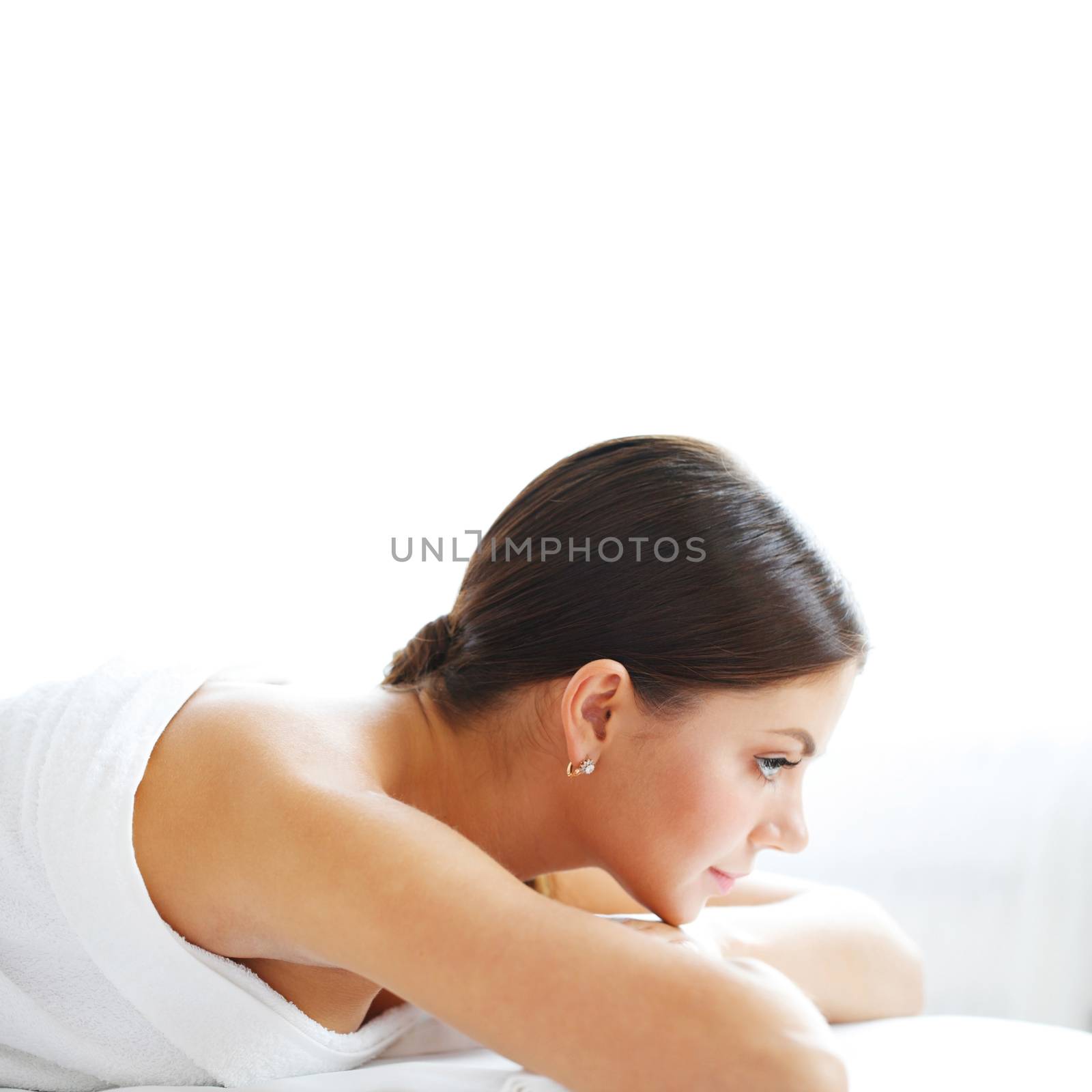 Happy beautiful young woman on massage table isolated on white