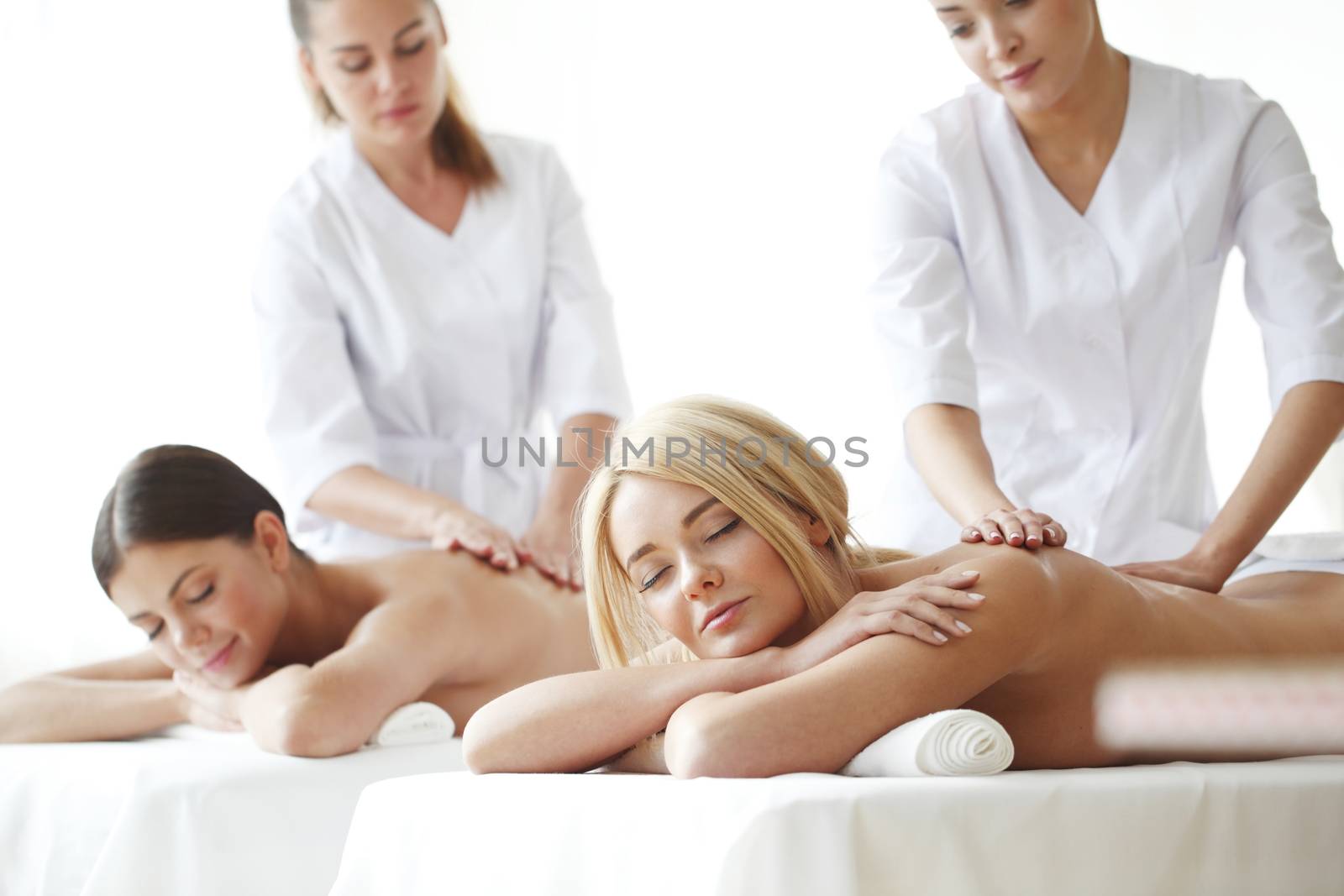 Two beautiful women getting massage in spa