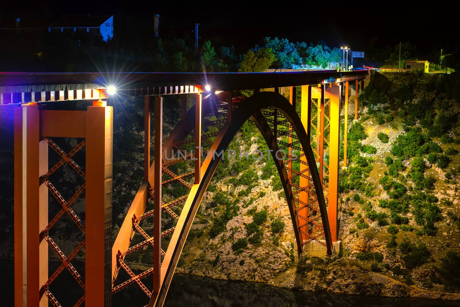Illuminated bridge at night, steel arch construction, light trails of cars, old Maslenica bridge near Zadar, Croatia