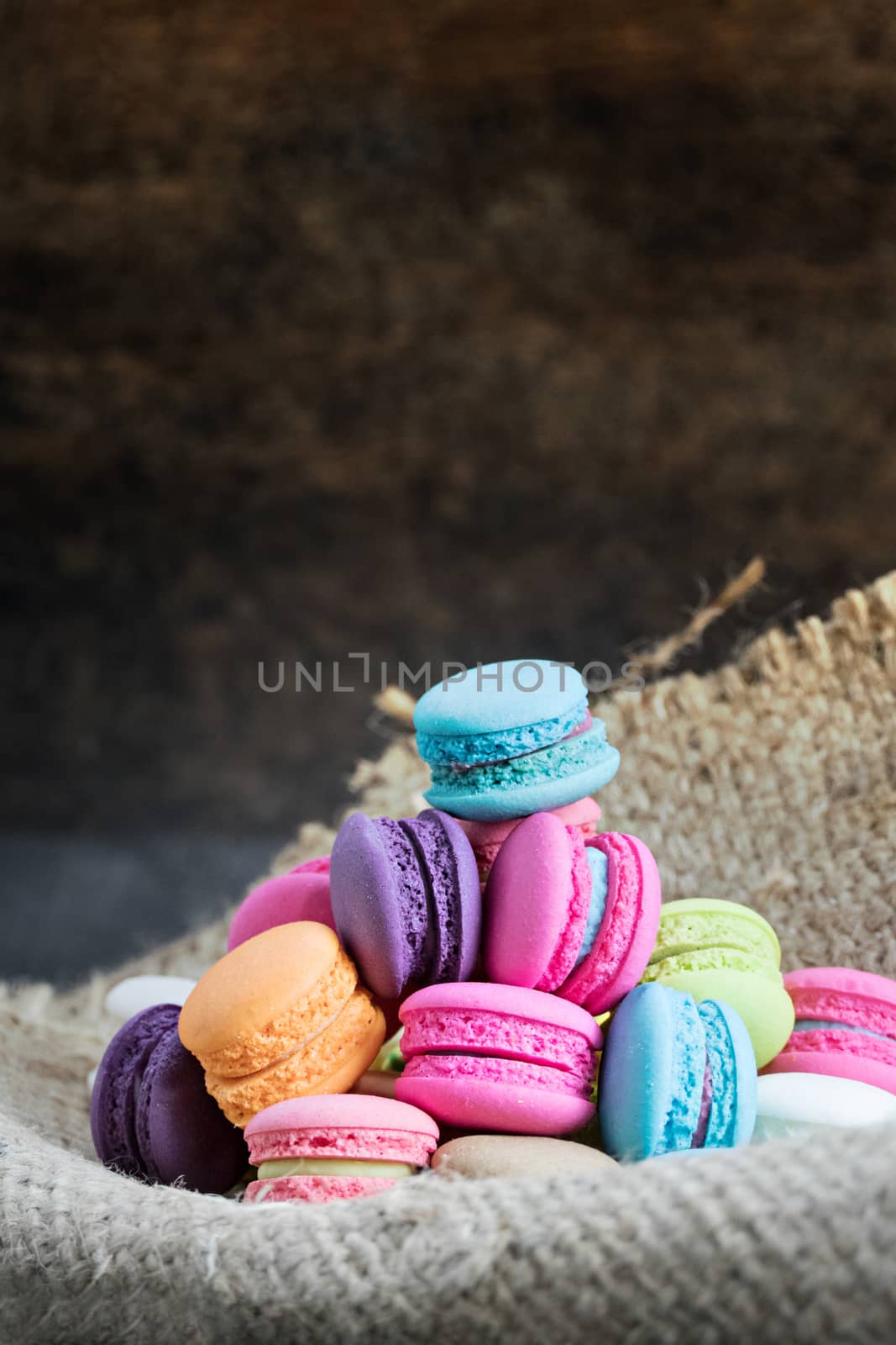 colorful of macarons on a sack over wooden table