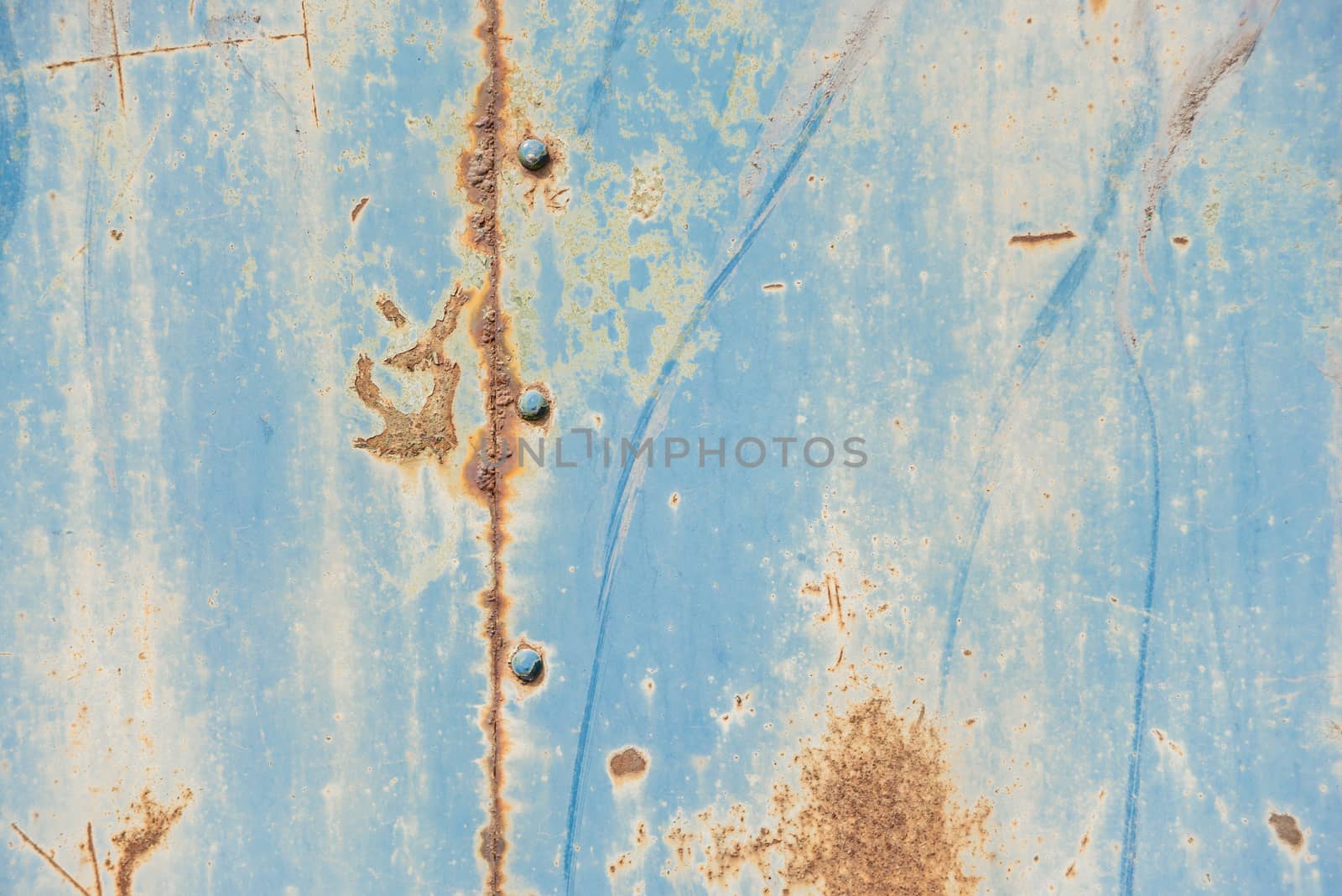 Grunge background: rusty metal surface covered with blue paint flaking and cracking texture, with seam and rivets