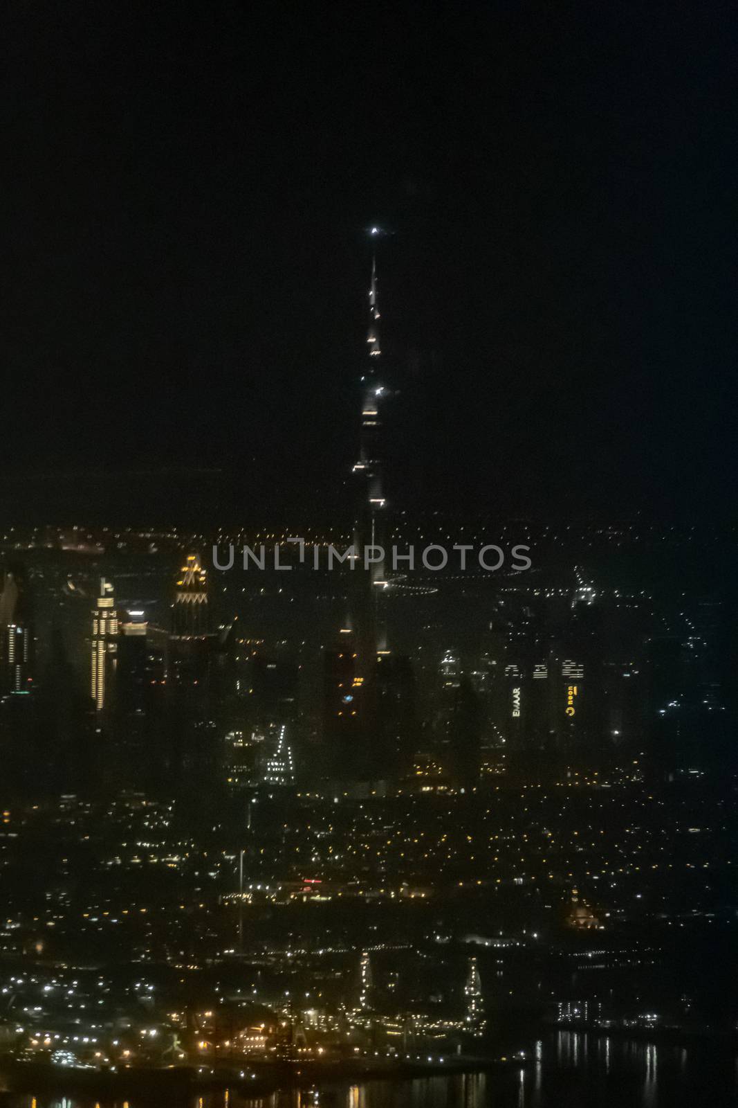 Skyline of Dubai VAE Burj Khalifa in the dark as seen from airplane by MXW_Stock