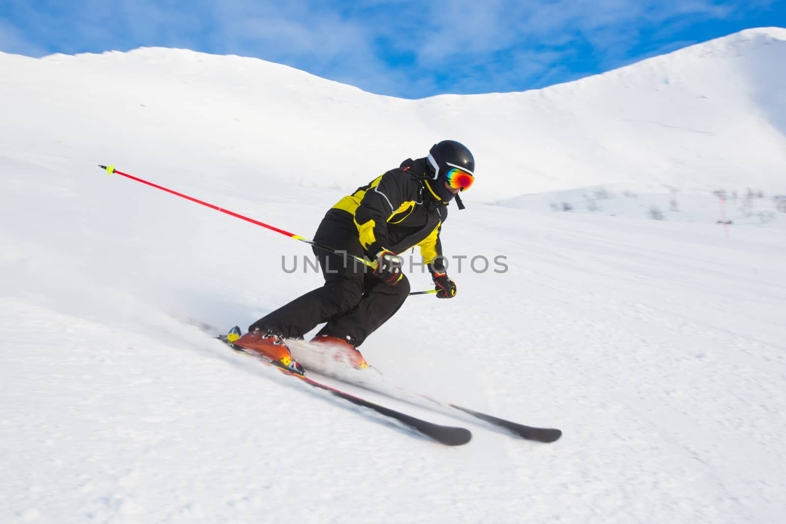 Professional athlete skier training the race of super g skiing downhill on slope in winter mountains on sunny day