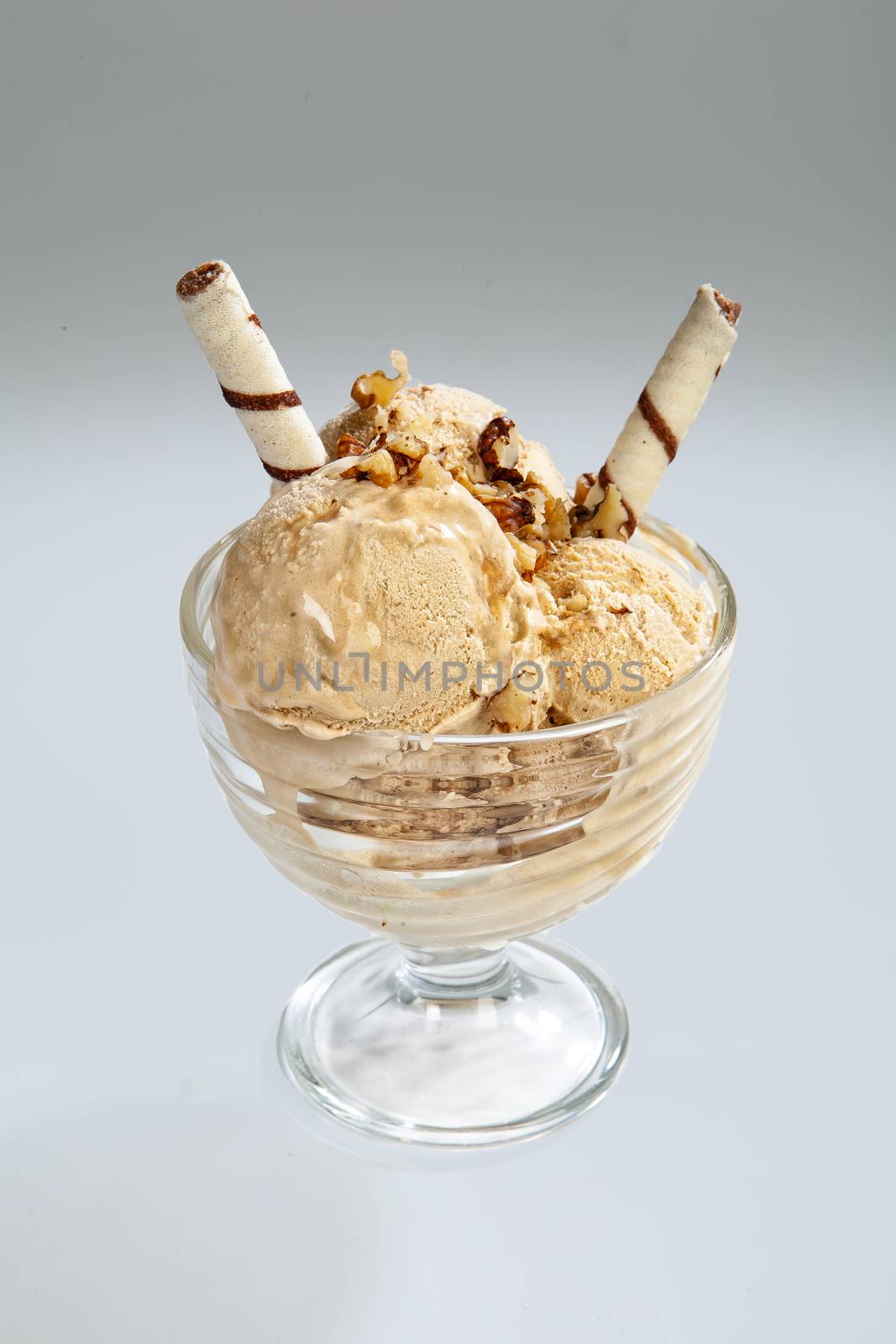 Glass with icecream and cookies on a studio background