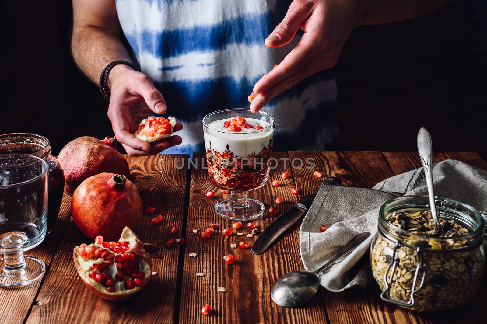 Man Decorates Dessert with Pomegranate Seeds. by Seva_blsv