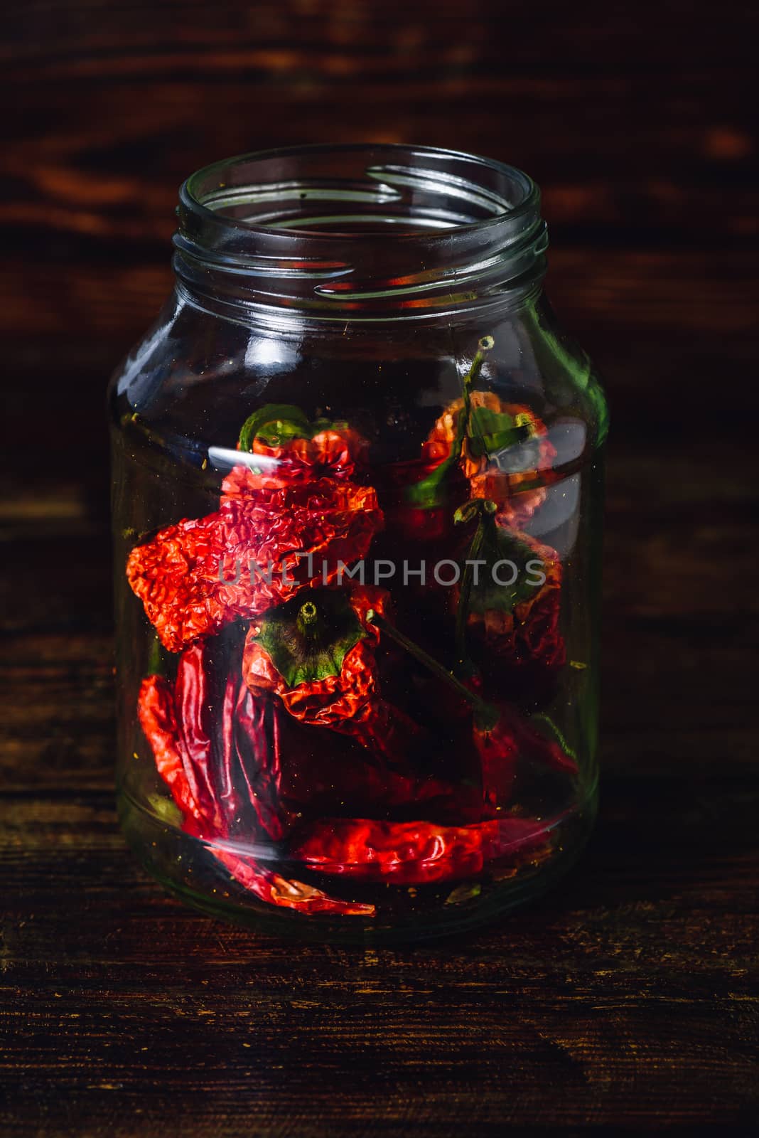 Jar of Dried Red Chilies on Wooden Background.