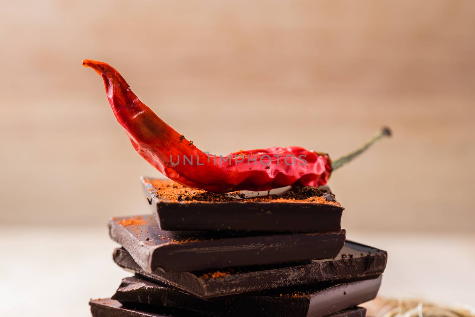 Dry red chili peppers on chocolate bars with cayenne powder.
