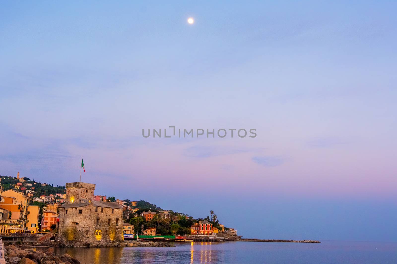 panorama of an italian sea village with space for text and moon high in the sky - Rapallo - italy town copyspace background night sunset