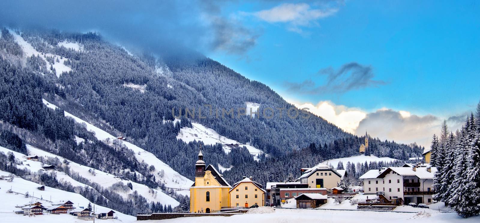 panoramic overview church snowy valley beautiful winter sunny day Trentino Alto Adige Italy by LucaLorenzelli