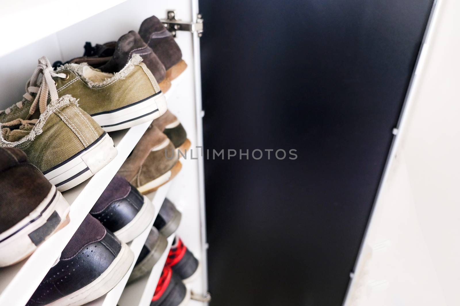 shoe rack of sneakers shoes close up shelf by LucaLorenzelli