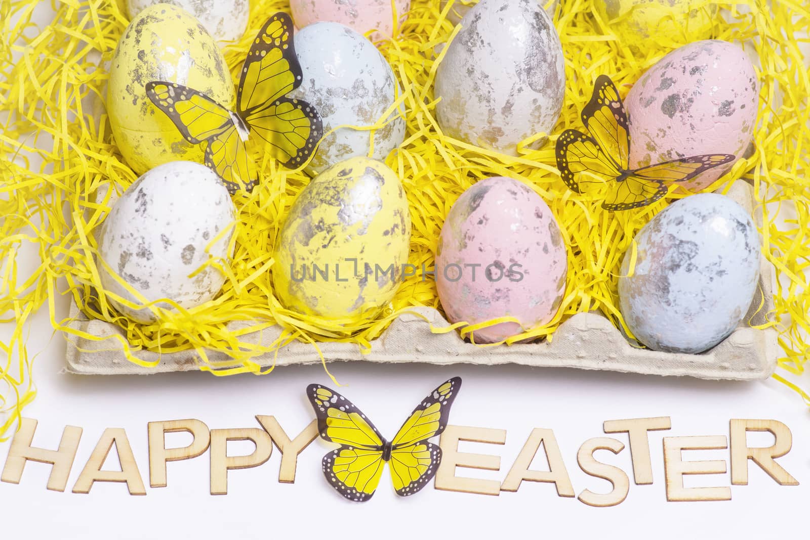 Happy Easter.Multi-colored Easter eggs on a white background with a bunch of wooden letters Happy Easter.