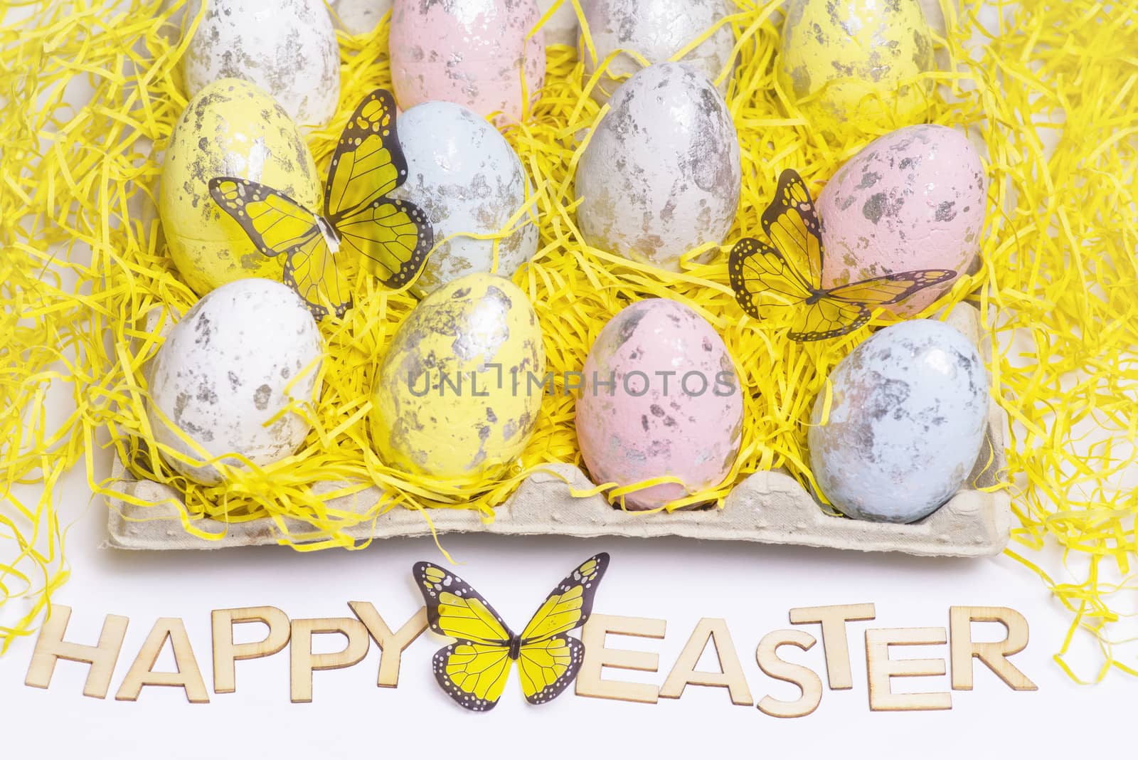 Happy Easter.Multi-colored Easter eggs on a white background with a bunch of wooden letters Happy Easter.
