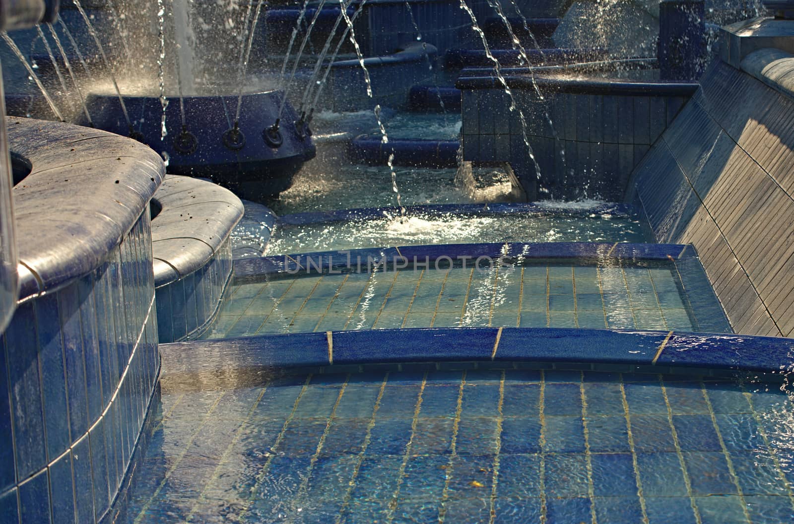 Fountain made of blue ceramic tiles with water splashing around