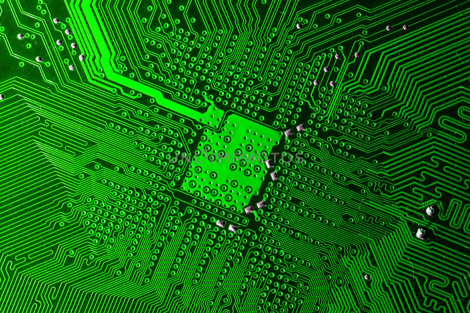 Close up photo of green printecd circuit board with solder points