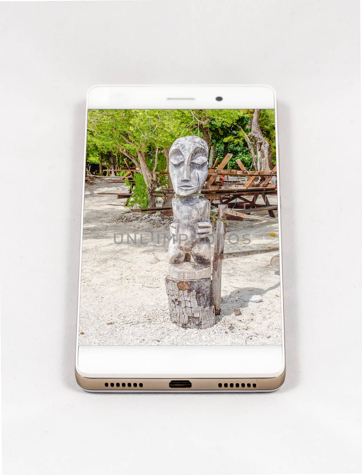 Smartphone with full screen picture of wood statue, French Polynesia. Concept for travel smartphone photography. All images in this composition are made by me, separately available on my portfolio