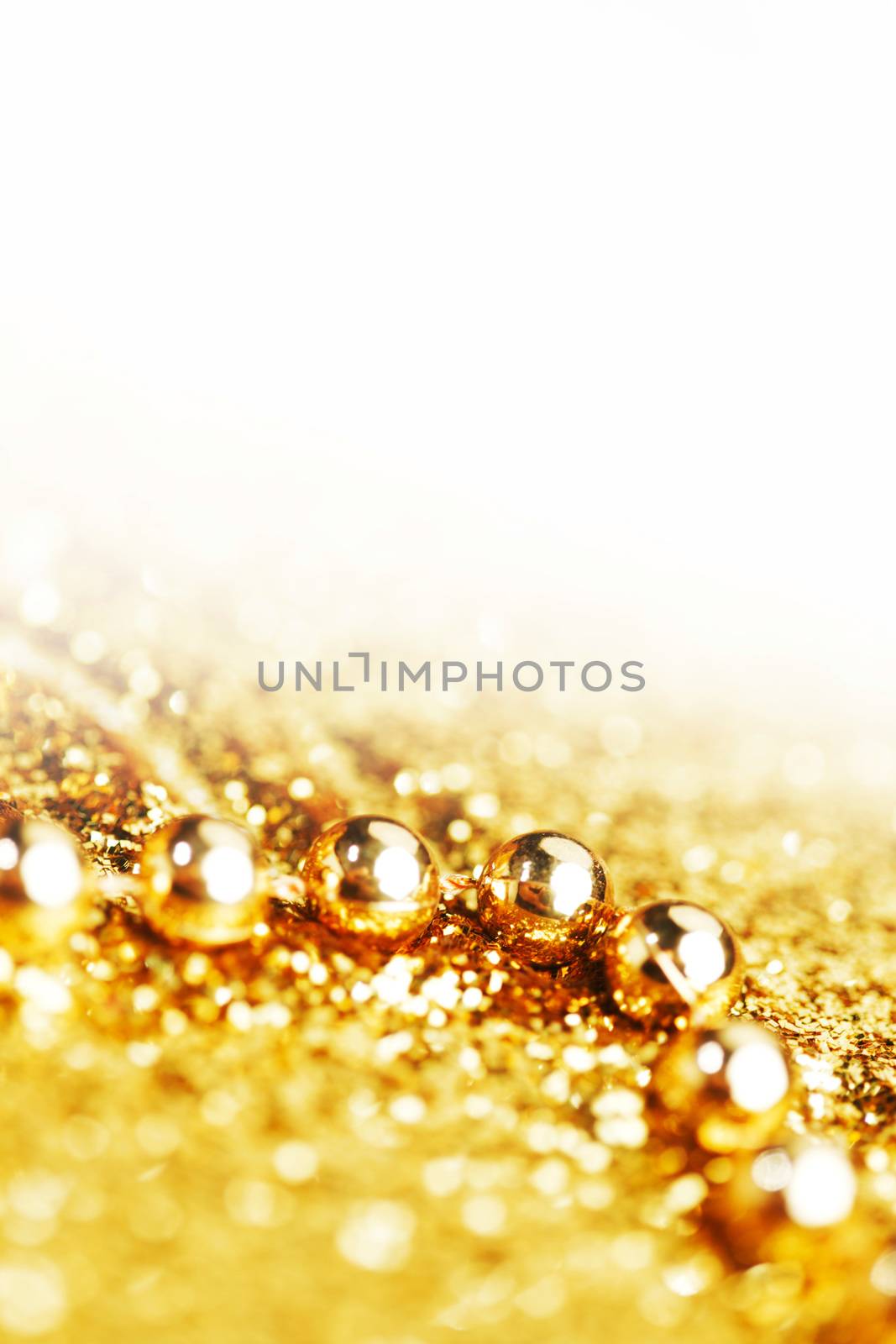 Golden decorative christmas beads on glitter background with white copy space