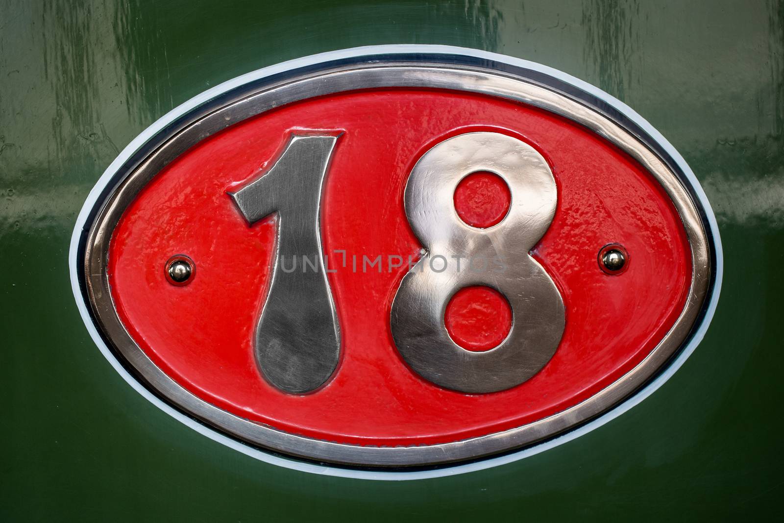 Plate with number eighteen, detail of an old metal plate with information and numbers