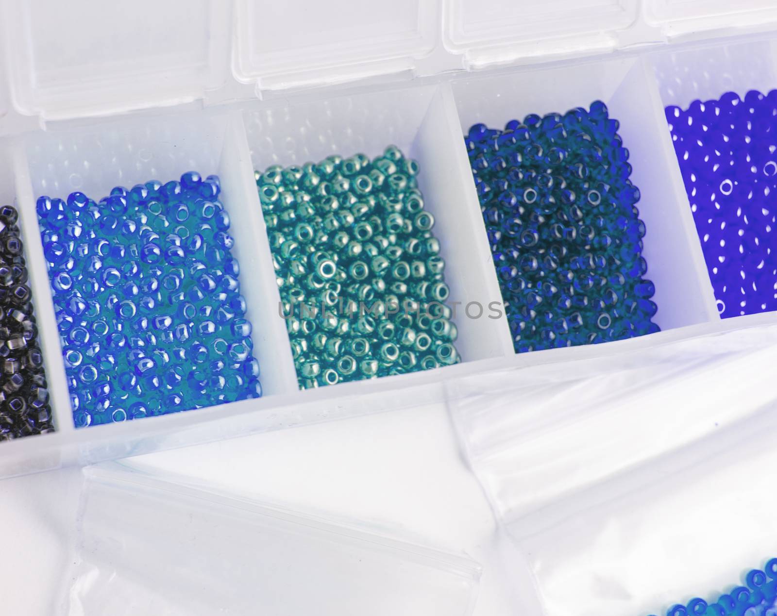 Fletley, plastic box with colorful beads for creativity and hobby, Bright sparkling beads on white background by claire_lucia