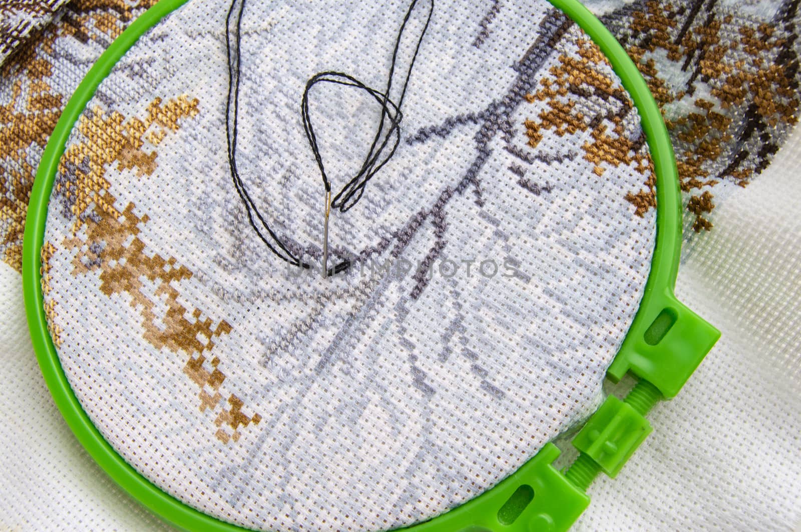 Flat lay embroidery Hoop with canvas and bright sewing thread and embroidery needle.