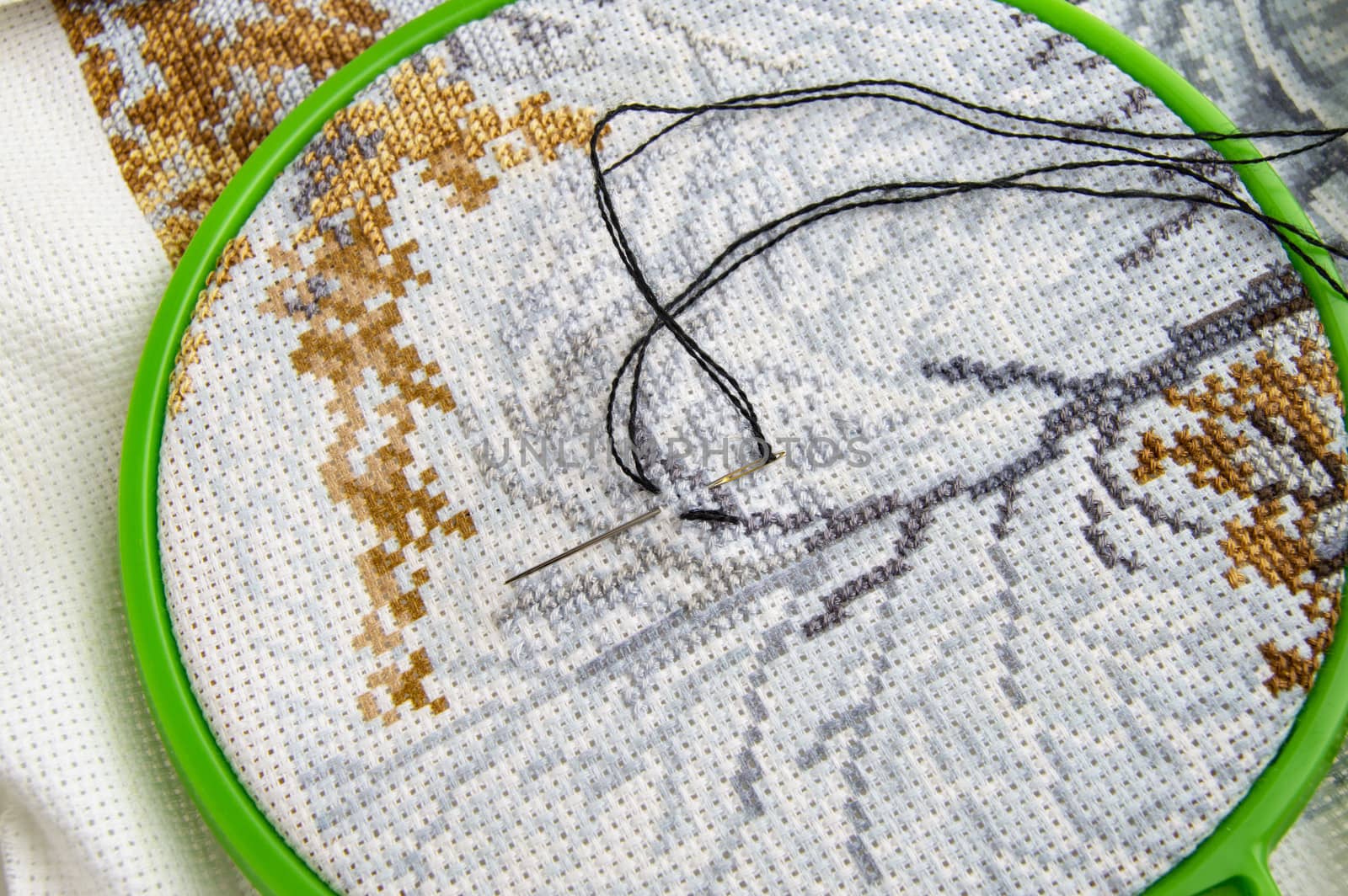 Flat lay embroidery Hoop with canvas and bright sewing thread and embroidery needle.