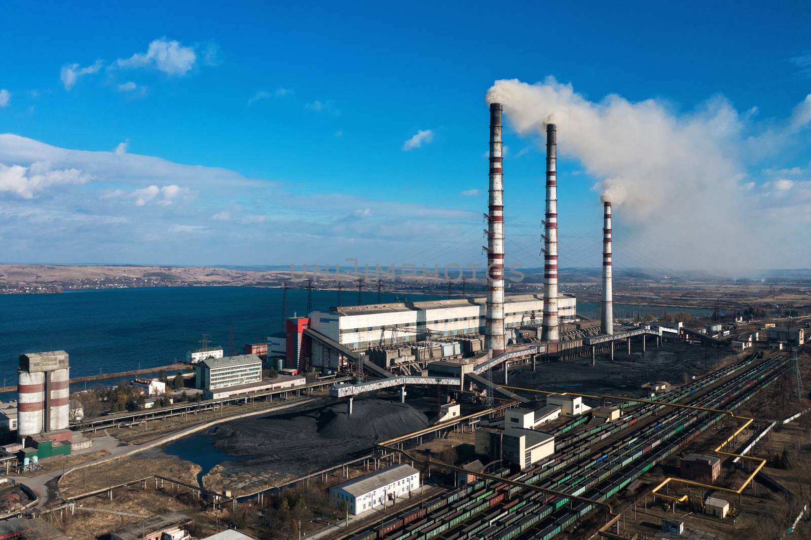 Old thermoelectric plant with big chimneys in a rural landscape. Burshtyn, Ukraine