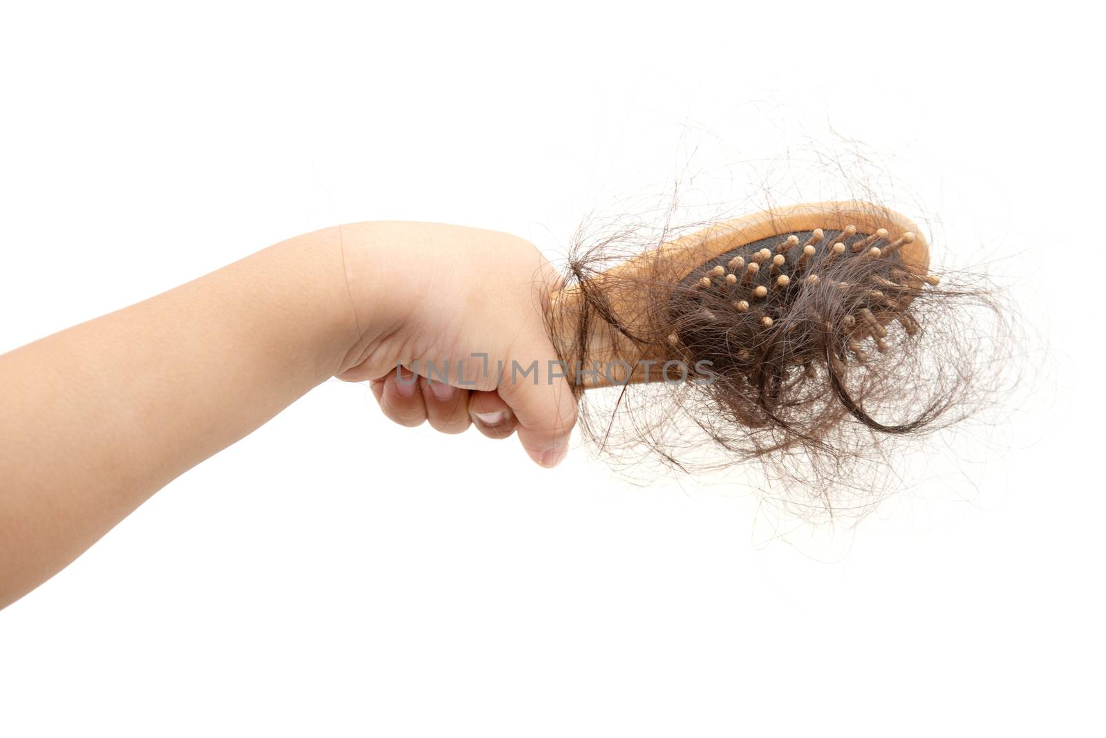 Children hand holding comb with lost hair on it, isolated on white background.