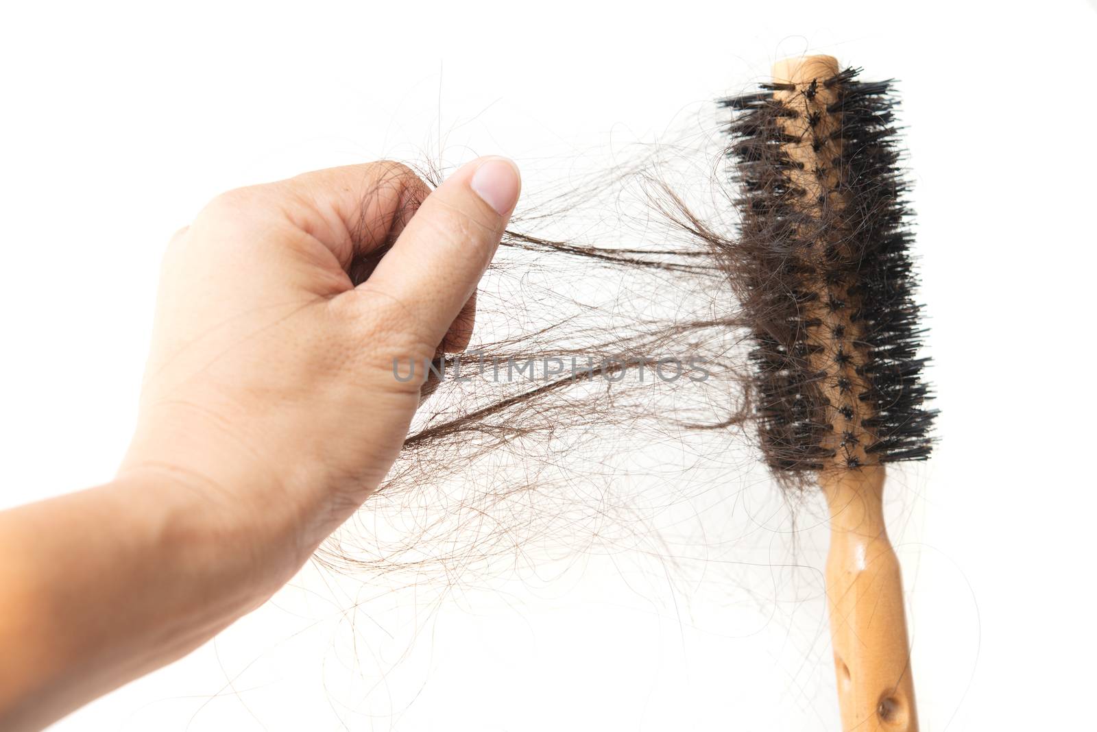 Human hand grabbing lost hair on brush, isolated on white background.