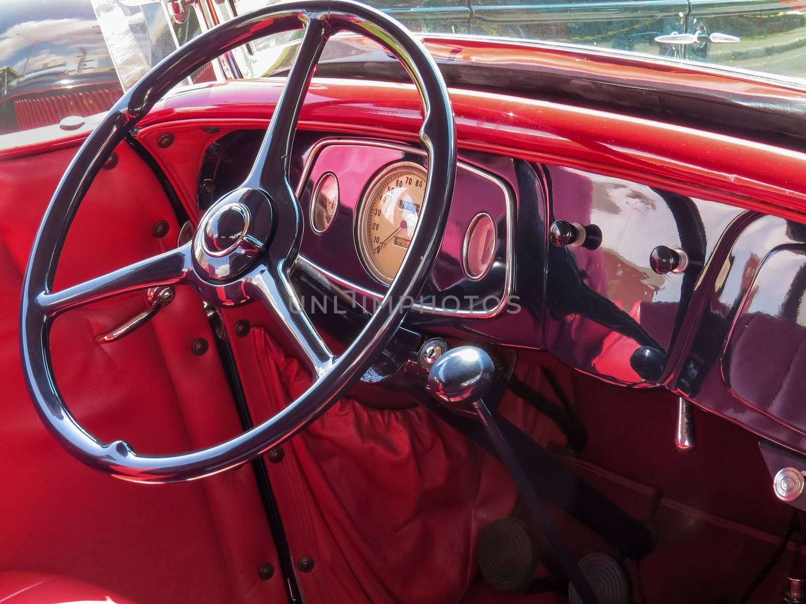 Red interior with classic car dashboard and steering wheel. by silviopl