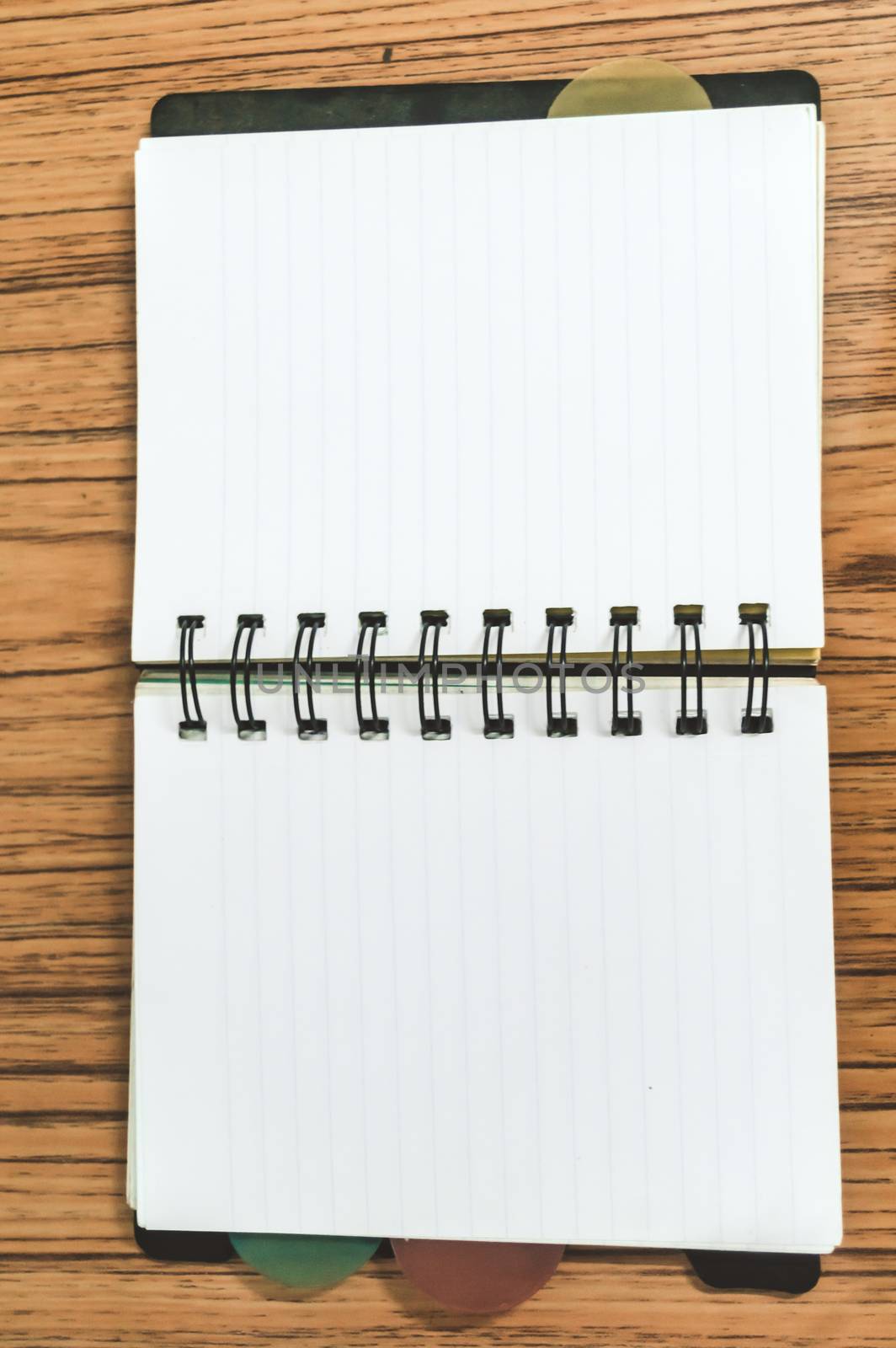Blank empty notepad on a wood table. Top view image of open pocket planner notebook with empty pages ready for adding text or mockup. by sudiptabhowmick