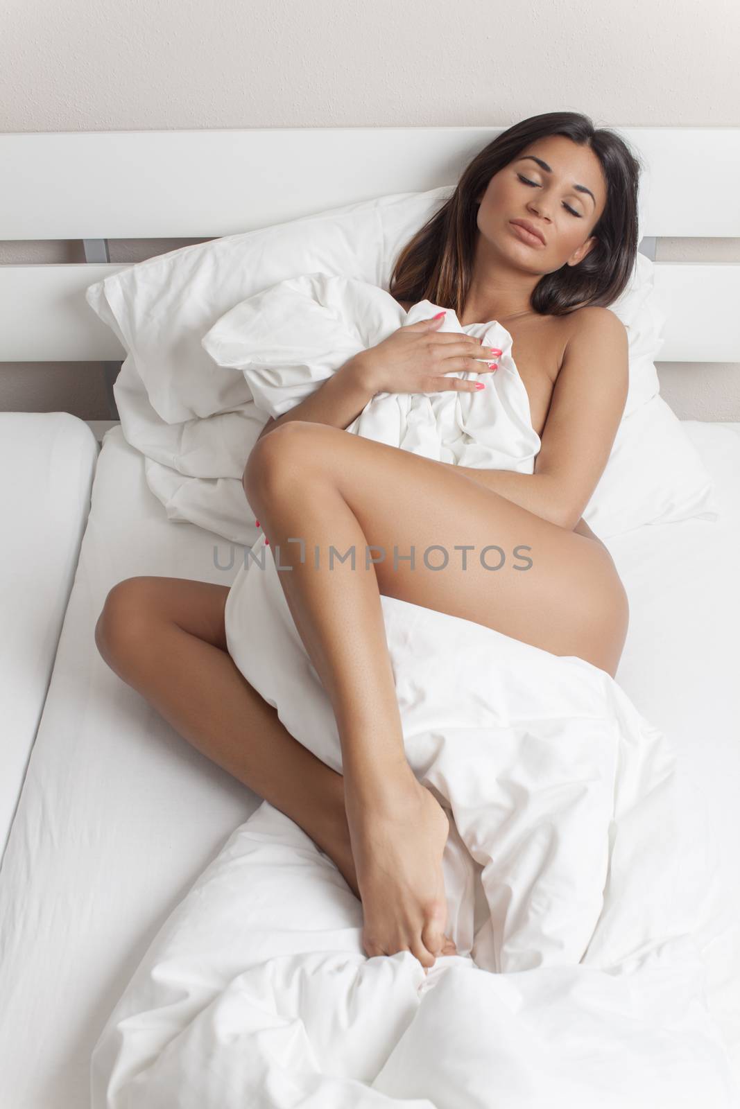 brunette woman lying in bed by bernjuer