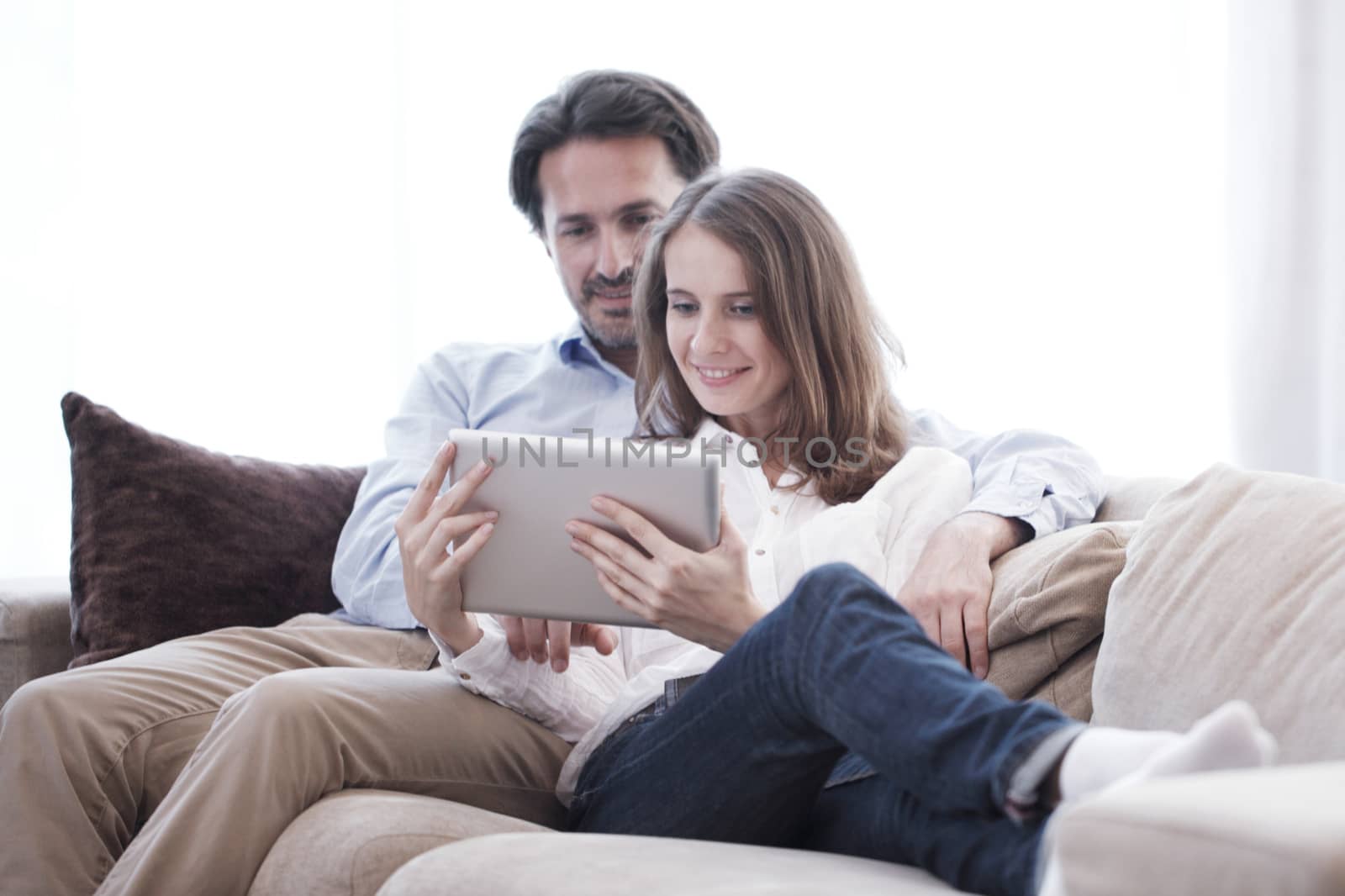 Cheerful couple using tablet  by ALotOfPeople