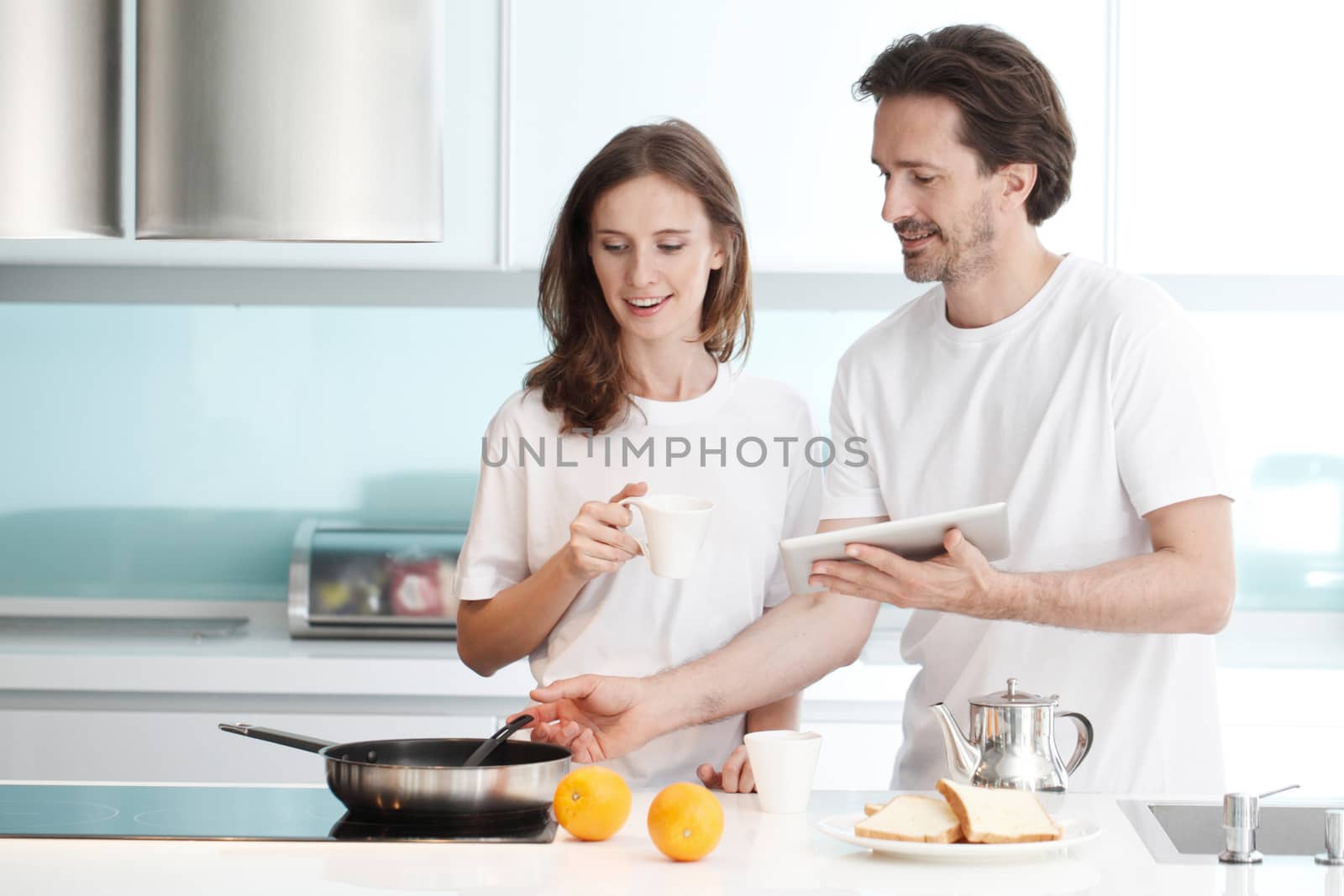Happy couple cooking breakfast together in the kitchen