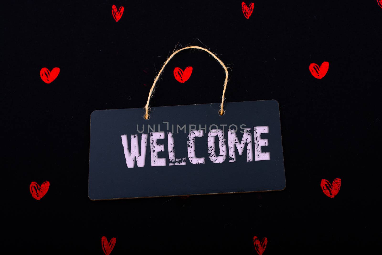 Welcome wording on black notice board  with red hearts around