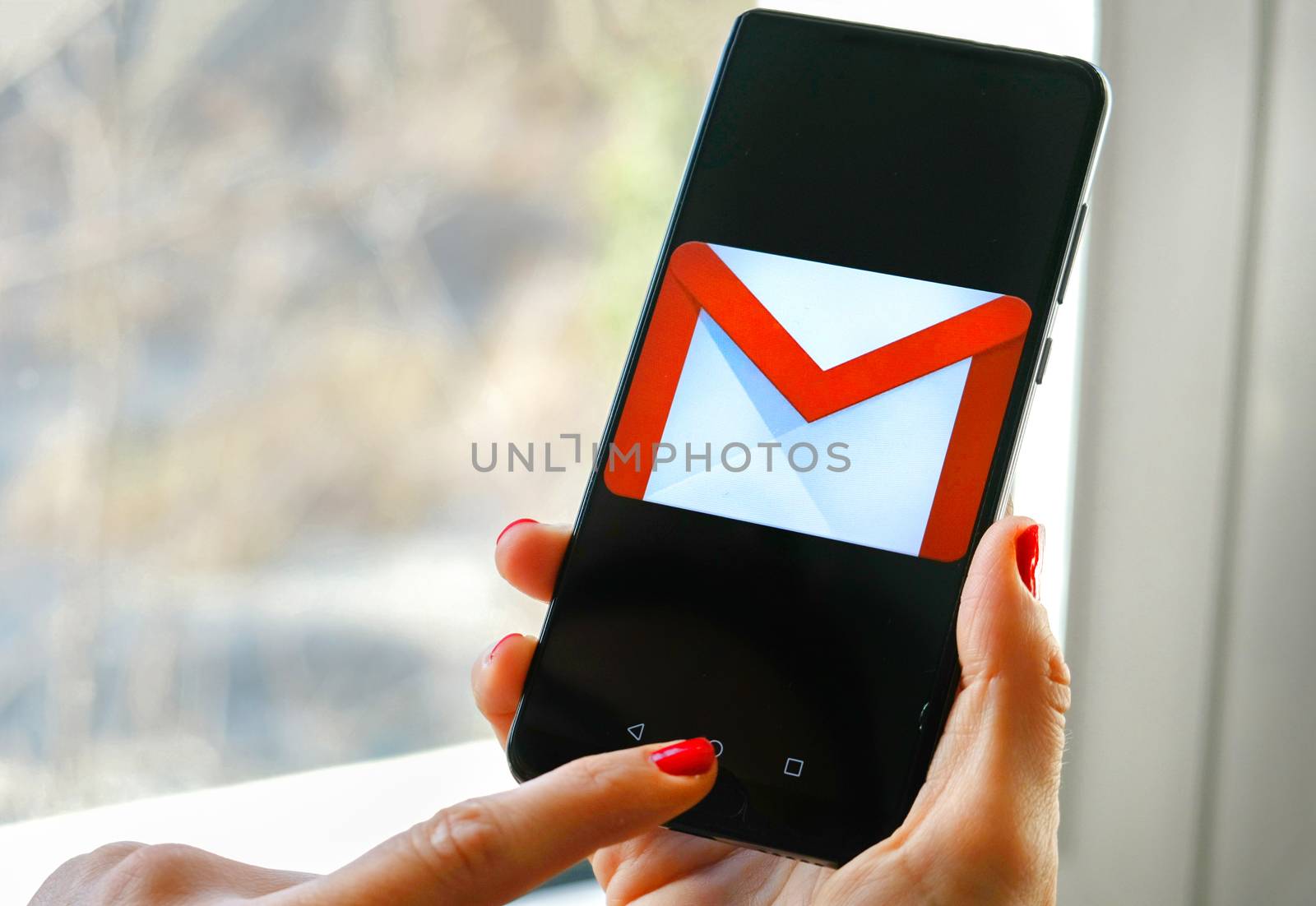 hand check emails Gmail app by Google on smartphone by LucaLorenzelli