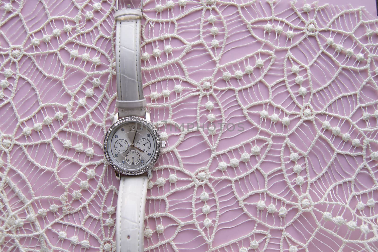 Stylized photo for business women, social networks, women's posts, modern women's wristwatch on a noble lace and pink background. Empty space