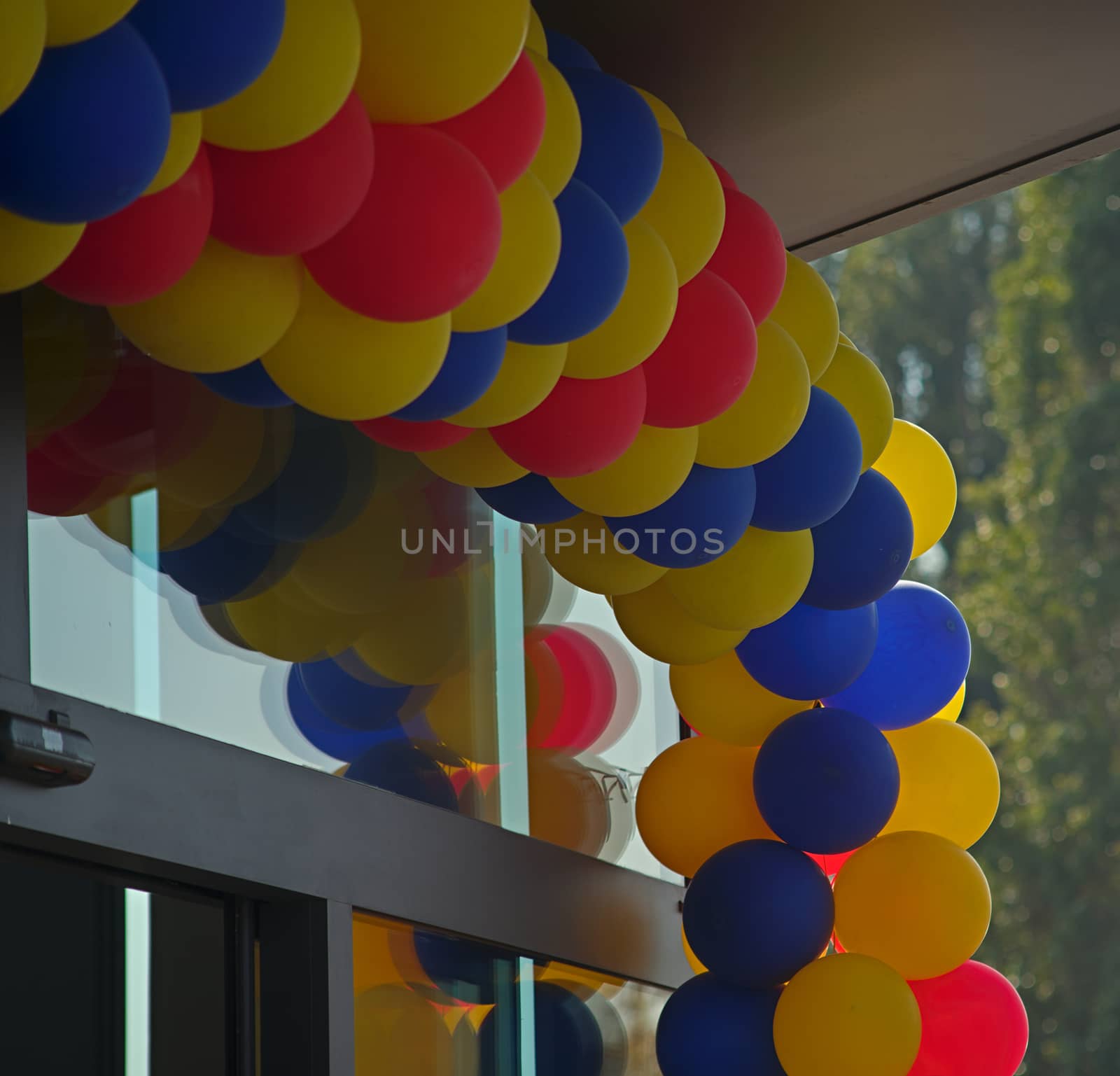Colorful balloons over glass entrance door by sheriffkule