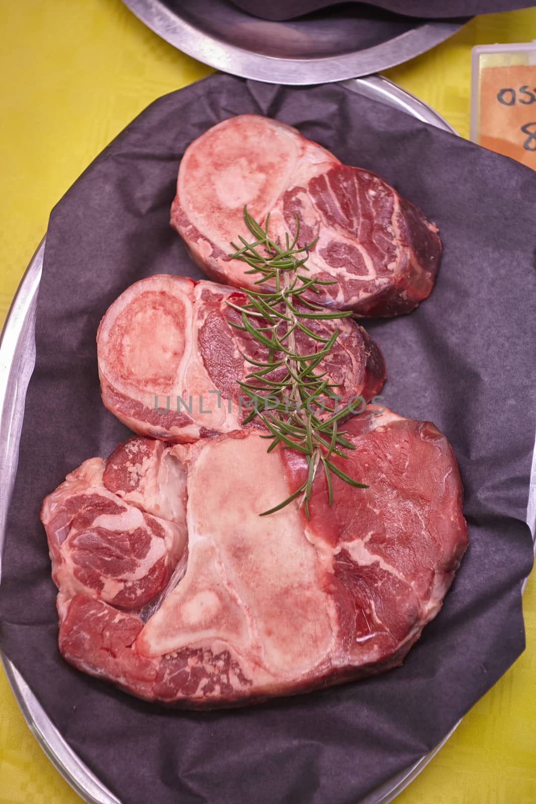 Raw veal meat cuts displayed in a cold counter with price tags ready for sale in the butcher's shop.