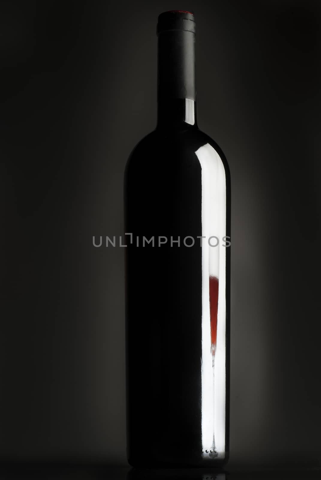 Bottle of wine, reflection of wine glass, red wine, black background