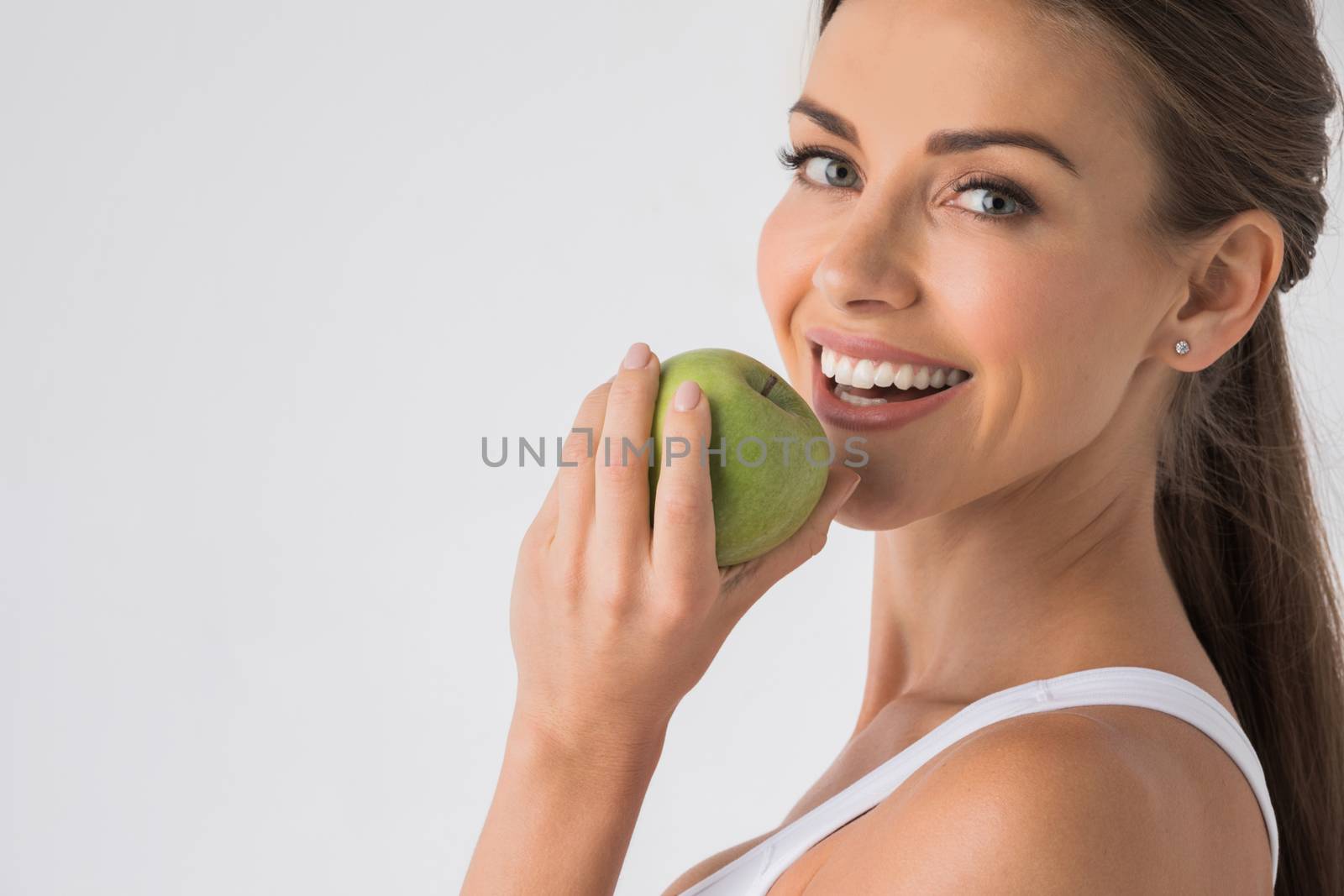 Woman biting green apple by Yellowj