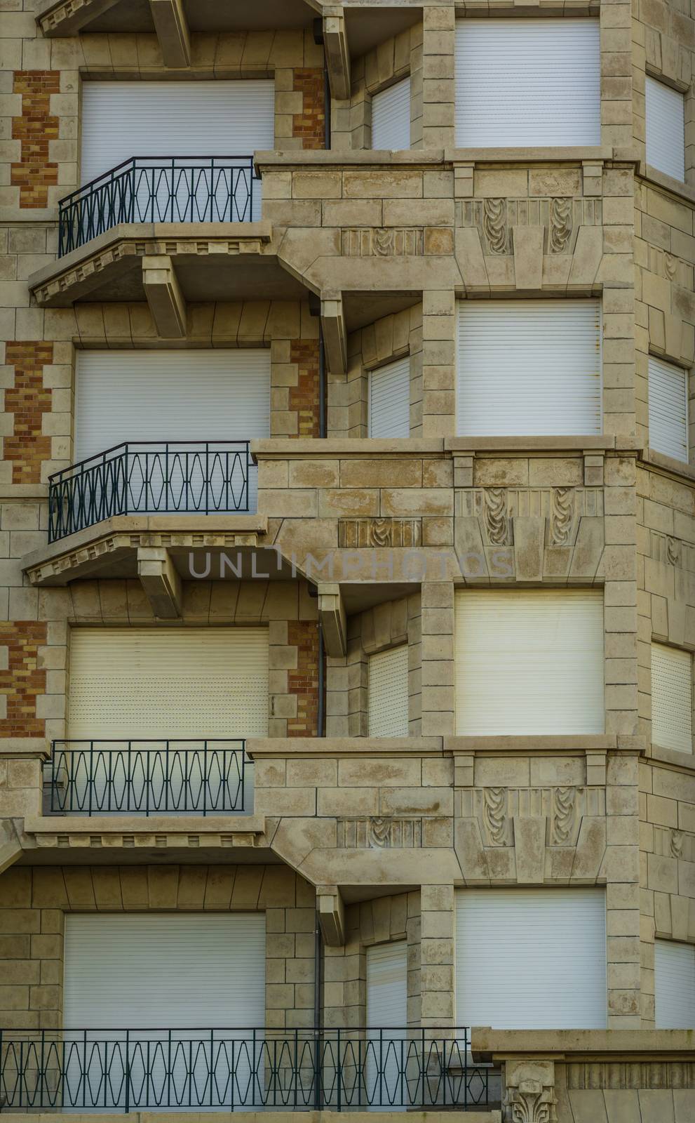 beautiful vintage building with balconies and closed roller shutters, Belgian city architecture