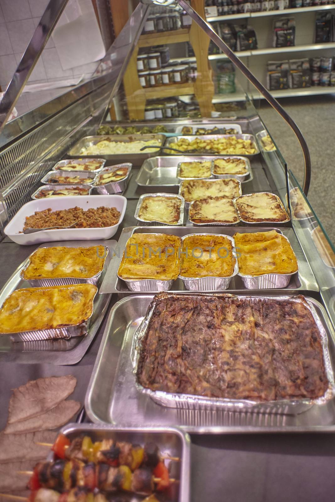 View of a refrigeration counter of a rotisserie full of cooked and ready to take away food